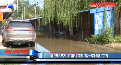 门前积水堵路 只因一道墙挡住了去路